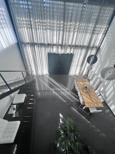 a living room with a table and a window at Olivujoj Villajoj - Deluxe Villa with Detached Pool House in Anavissos