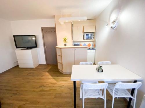 - une cuisine avec une table et des chaises blanches dans la chambre dans l'établissement Azur- 4 pers Hyper centre - Plage à 2 mn à pied - Terrasse, à Saint-Raphaël