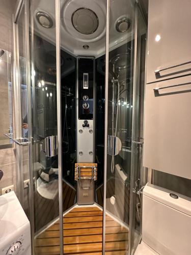 une douche avec une porte vitrée dans une salle de bain dans l'établissement Village naturiste - Port-Vénus - Les coquelicots, au Cap d'Agde