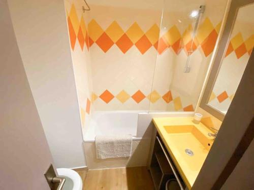 La salle de bains est pourvue d'un lavabo jaune et d'un miroir. dans l'établissement Azur- 4 pers Hyper centre - Plage à 2 mn à pied - Terrasse, à Saint-Raphaël