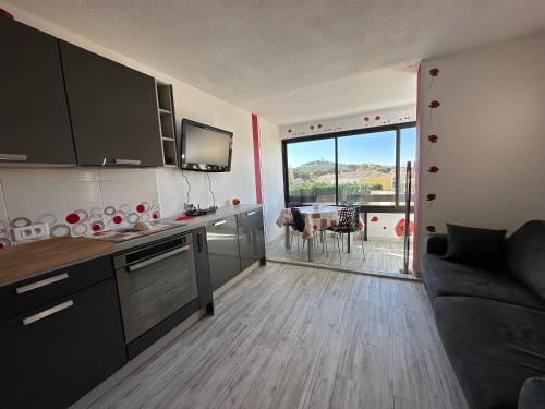 - une cuisine avec un canapé et une table avec vue dans l'établissement Village naturiste - Port-Vénus - Les coquelicots, au Cap d'Agde