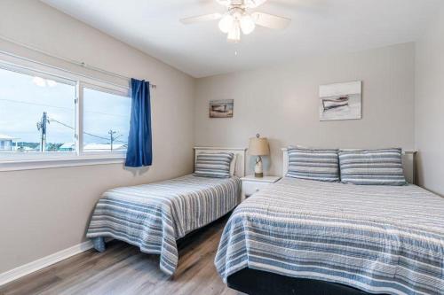 a bedroom with two beds and a window at Bonhomme Richard East in Gulf Shores