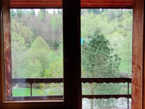 an open window with a view of a forest at Chata Pod Kwiatkiem in Zawoja