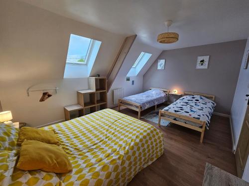 two beds in a room with two windows at Gîtes Nos jours heureux - L'escapade, maison de campagne in Étienville