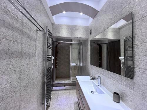 a bathroom with a sink and a mirror at Olivujoj Villajoj - Deluxe Villa with Detached Pool House in Anavissos