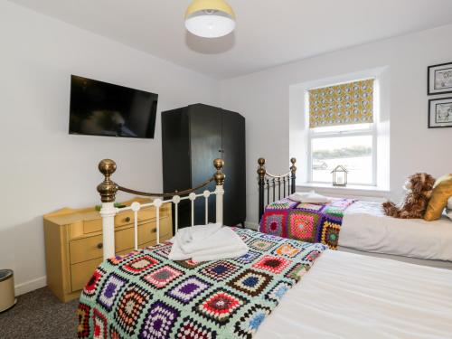 a bedroom with two beds with a quilt on it at Smithy House in Dumfries