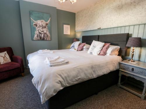 a bedroom with a bed with a picture of a cow on the wall at Smithy House in Dumfries