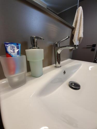 um lavatório de casa de banho com uma torneira e uma escova de dentes em Stephie's apartment by the sea em Rafina