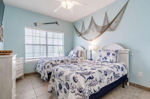 2 camas en un dormitorio con paredes azules en Orange Beach Villas - Casa Bella en Orange Beach