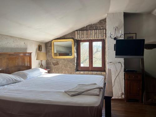 una camera da letto con un letto, una finestra e una televisione di Cottage Beach Vico a Caprarola