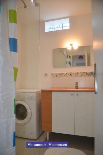 a bathroom with a washing machine and a mirror at Villa des 4 saisons in Saint-Trojan-les-Bains