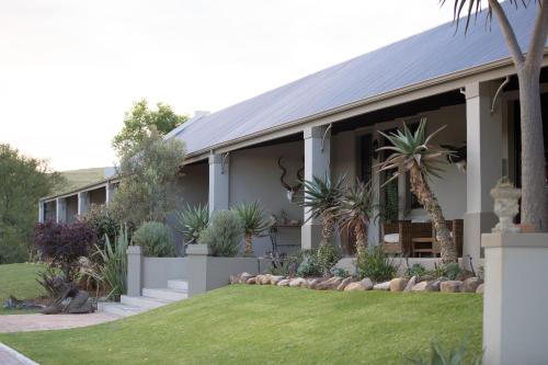 an exterior view of a house with plants at Swartberg Private Game Lodge in Oudtshoorn