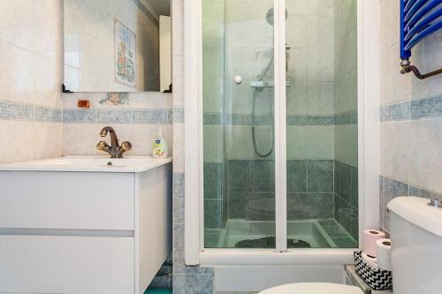 y baño con ducha, aseo y lavamanos. en Bel appartement aux portes de Paris, en Cachan