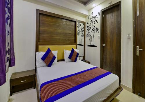a bedroom with a bed with blue and white pillows at Hotel University Stay @ A1Rooms in New Delhi