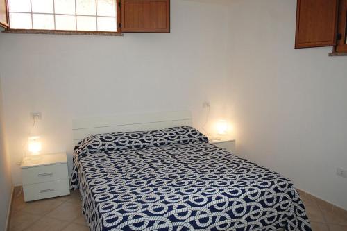 a bedroom with a black and white bed and a window at Nuovissimo appartamento a due passi dalla spiaggia di Maladroxia C61 in Maladroxia