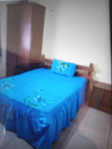 ein blaues Bett mit blauer Bettwäsche in einem Zimmer in der Unterkunft Casa Cabo frio in Cabo Frio