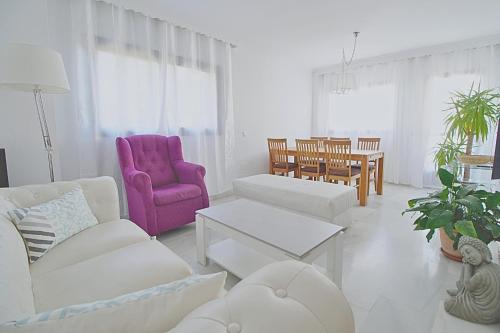 a living room with white furniture and a purple chair at ApartRincón Las Minas in Rincón de la Victoria