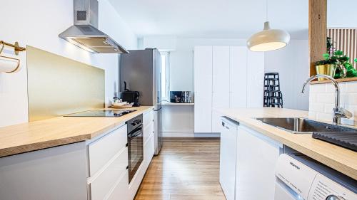 une cuisine avec des armoires blanches et un comptoir en bois dans l'établissement Le Joyeux - Idéal Groupe - Parking Gratuit, à Troyes