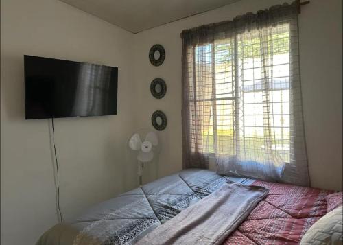 a bedroom with a bed and a flat screen tv at Apartamento entero Rebeca house in Santa Ana