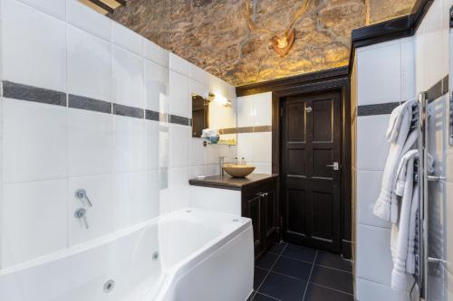 a bathroom with a tub and a sink at Dornoch Castle Hotel in Dornoch