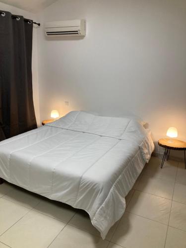 ein Schlafzimmer mit einem großen weißen Bett und einem Tisch in der Unterkunft Guest house in Le Rouret