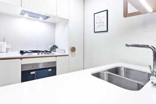 una cucina bianca con lavello e fornello di Luxury apartment in Mel east with special kids bed a Doncaster