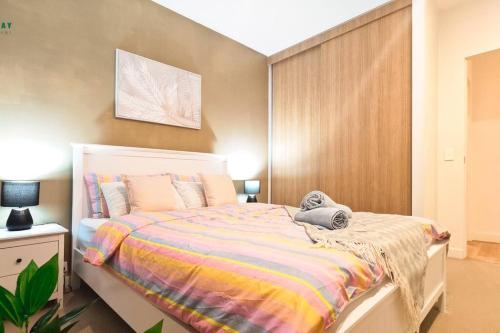 a bedroom with a bed with a colorful blanket at Luxury apartment in Mel east with special kids bed in Doncaster
