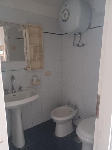 bagno bianco con lavandino e servizi igienici di Monolocale Ventotene a Ventotene