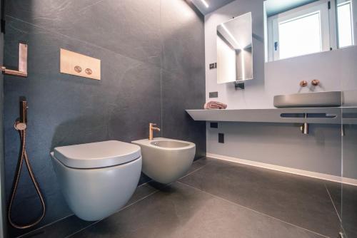 a bathroom with a toilet and a sink at Dedde Home in Aosta