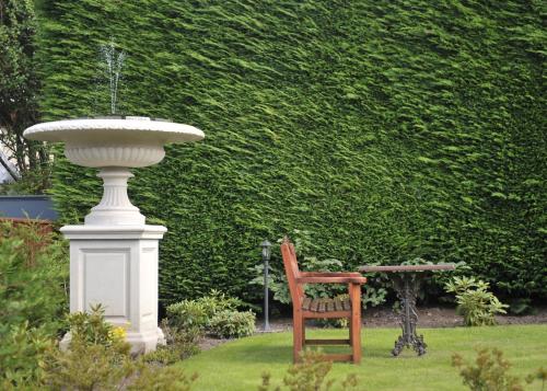 a chair sitting next to a fountain in a garden at Braid Hills Hotel in Edinburgh