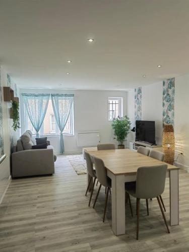 a living room with a dining room table and a couch at Bel appartement bord du Rhône in Valence