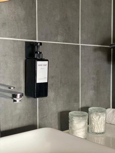 un distributeur de savon sur le mur d'une salle de bains dans l'établissement Kazeths Chambre chez l'habitant, à Toulouse