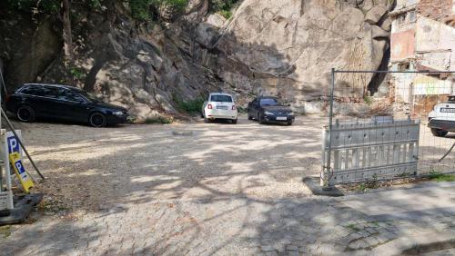 three cars parked in a parking lot next to a mountain at Plovdiv City Center Hotel in Plovdiv