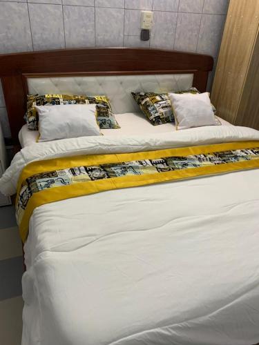 2 Betten in einem Zimmer mit weißer Bettwäsche und Kissen in der Unterkunft Good Vibes in Cotonou