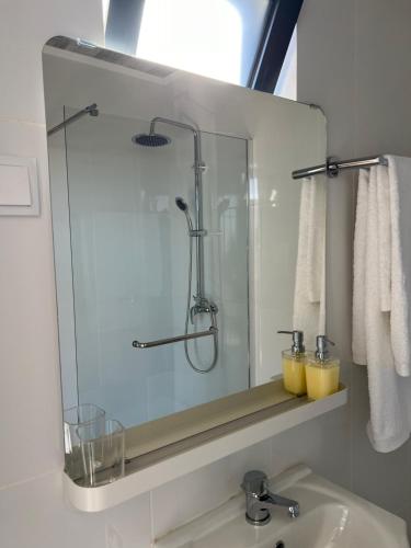 a bathroom with a sink and a glass shower at Success House in Calheta