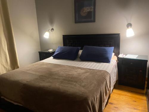 a bedroom with a large bed with two blue pillows at A cosy Apartment just for you to relax in 6th Of October