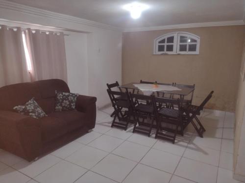- un salon avec une table, des chaises et un canapé dans l'établissement Apartamento espaçoso, à Cabo Frio