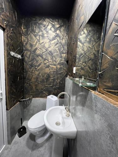 een badkamer met een wit toilet en een wastafel bij Grozno 2 in Tbilisi City