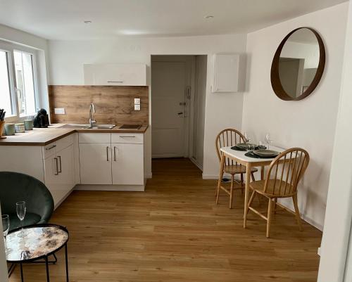 - une cuisine avec une table, des chaises et un miroir dans l'établissement Le XVII - Au cœur de Colmar, à Colmar