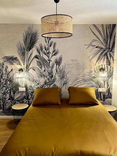 une chambre avec un grand lit jaune avec une fresque murale dans l'établissement Le XVII - Au cœur de Colmar, à Colmar