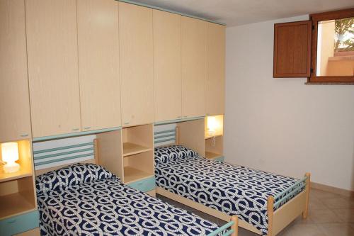 a room with two beds and cabinets in it at Appartamento con veranda e aria condizionata a Maladroxia C62 in Maladroxia