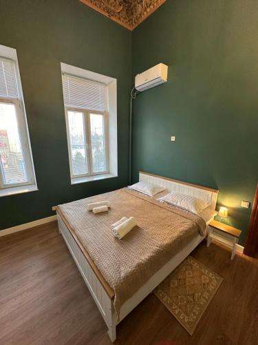 a bedroom with a bed with two towels on it at City Centre Apartment - Mari in Kutaisi