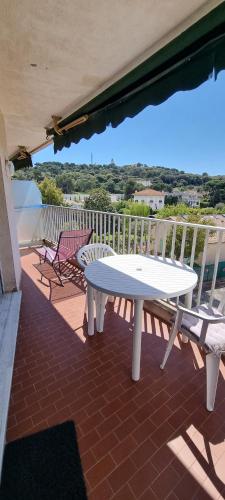 d'une table blanche et de deux chaises sur un balcon. dans l'établissement appartement plage de la Salis, à Antibes