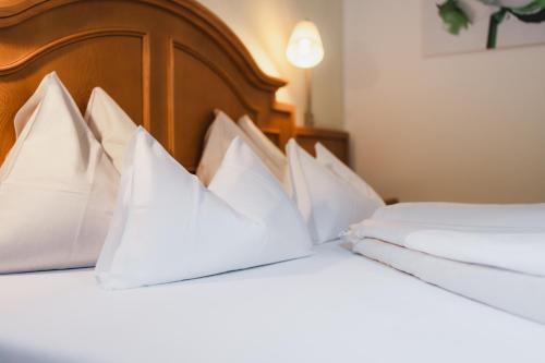 two beds in a hotel room with white pillows at Alpinhotel Berghaus spa in Tux