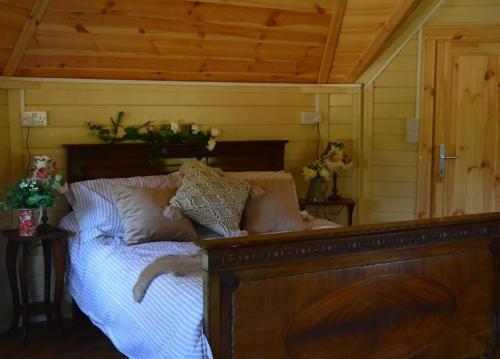 a bedroom with a wooden bed with pillows on it at Apple blossom glamping in Kilkenny