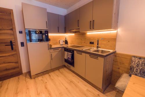 a small kitchen with a sink and a refrigerator at Alpinhotel Berghaus spa in Tux