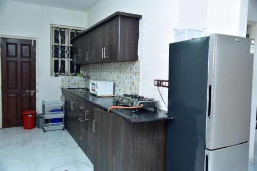 a kitchen with a black refrigerator and wooden cabinets at paradise villa in Varca