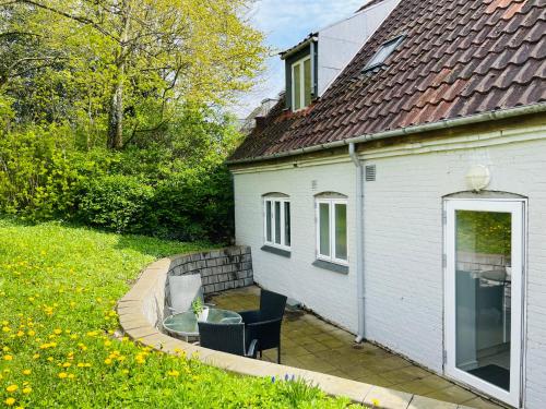 a white house with a table and chairs in a yard at Scandinavian House Hotel-Lunden- Central 3 bedroom house in Horsens
