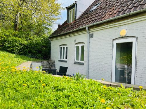 a white house with a window and chairs in a yard at Scandinavian House Hotel-Lunden- Central 3 bedroom house in Horsens