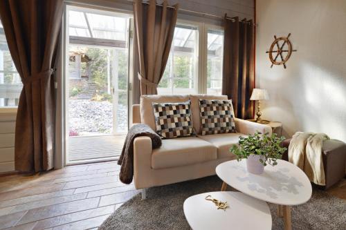 a living room with a couch and a window at Vuokatin Aateli Apartments in Vuokatti